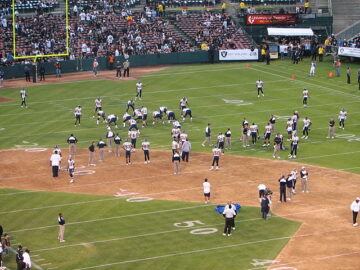 Chargers warmup with baseball field dirt overlaid on a football field in Oakland Coliseum